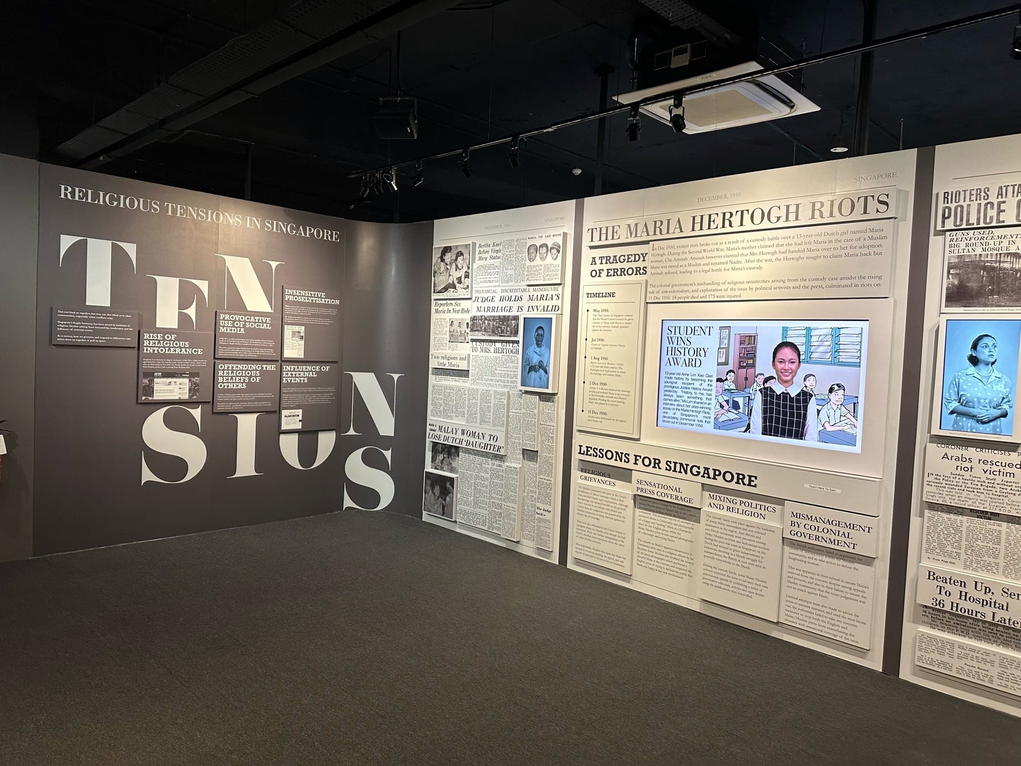 Museum exhibit on Religious Tensions in Singapore featuring panels about the Maria Hertogh Riots with newspaper clippings.